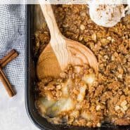 Crisp in a black baking dish, text overlay reads "pear crisp with ginger, rachelcooks.com"