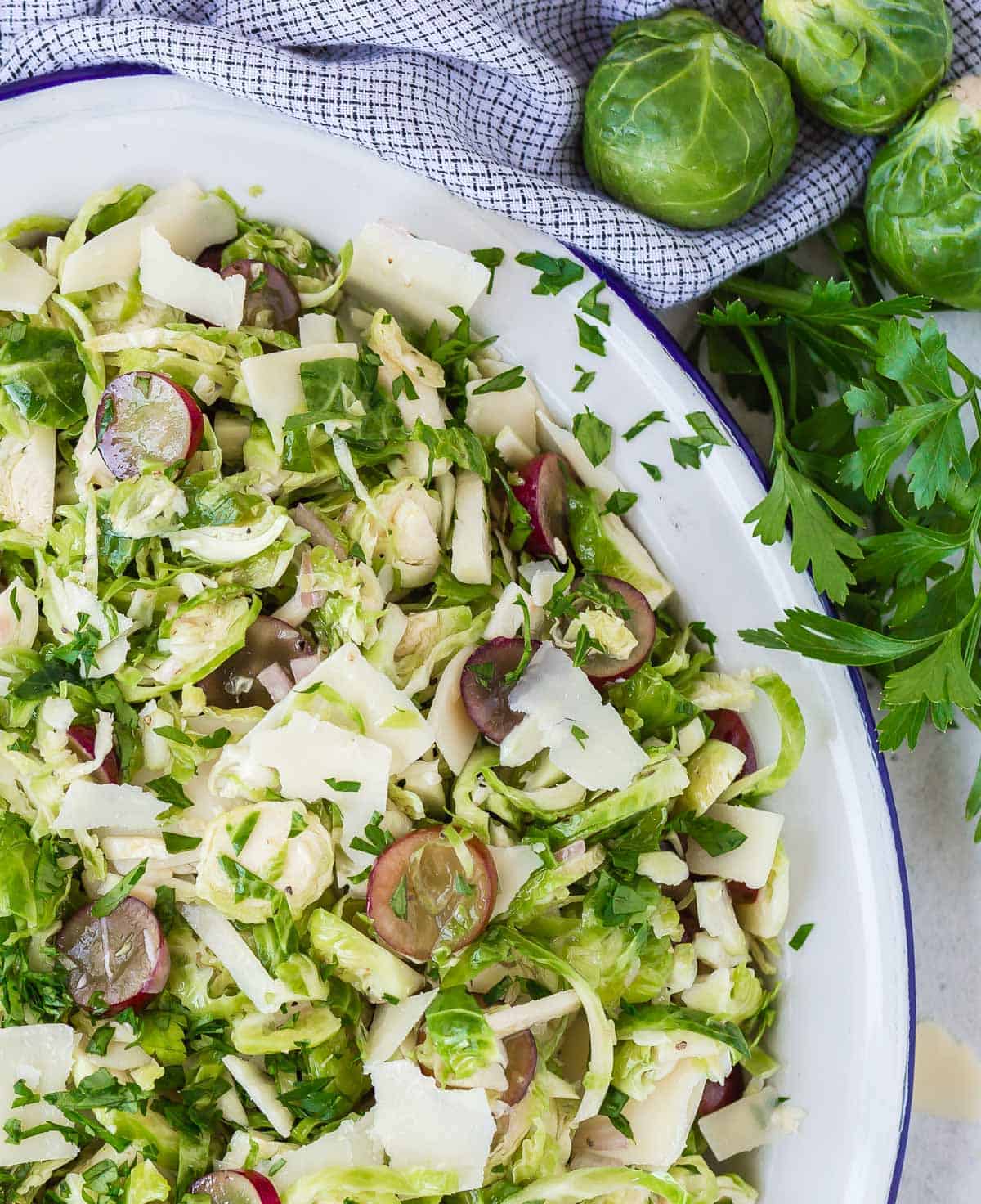 Close up view of salad with shaved brussels sprouts, grapes, and parmesan.