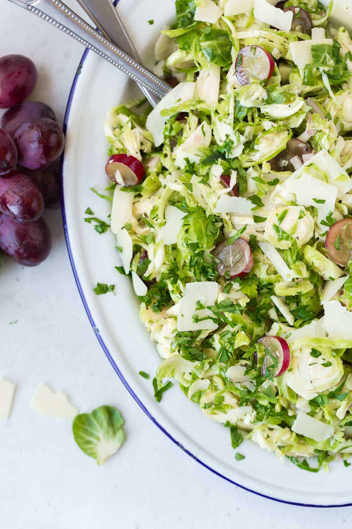 Shaved brussels sprouts salad with grapes, parsley, and parmesan cheese.