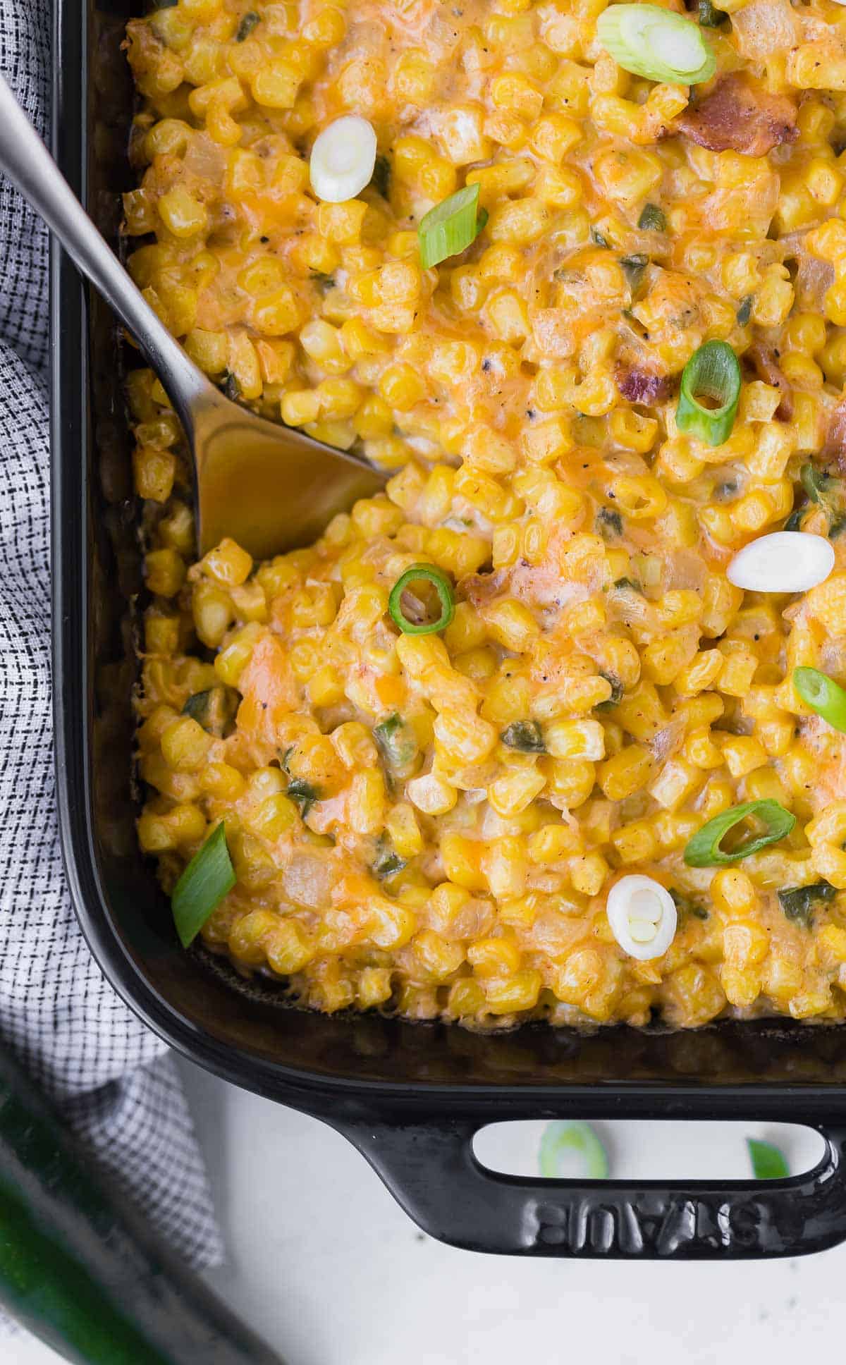 Overhead view of casserole made mainly of corn, sprinkled with sliced green onions.