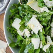 Overhead view of an arugula salad with a text overlay that reads "the best classic arugula salad, rachelcooks.com"