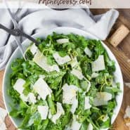 Overhead view of an arugula salad with a text overlay that reads "the best classic arugula salad, rachelcooks.com"