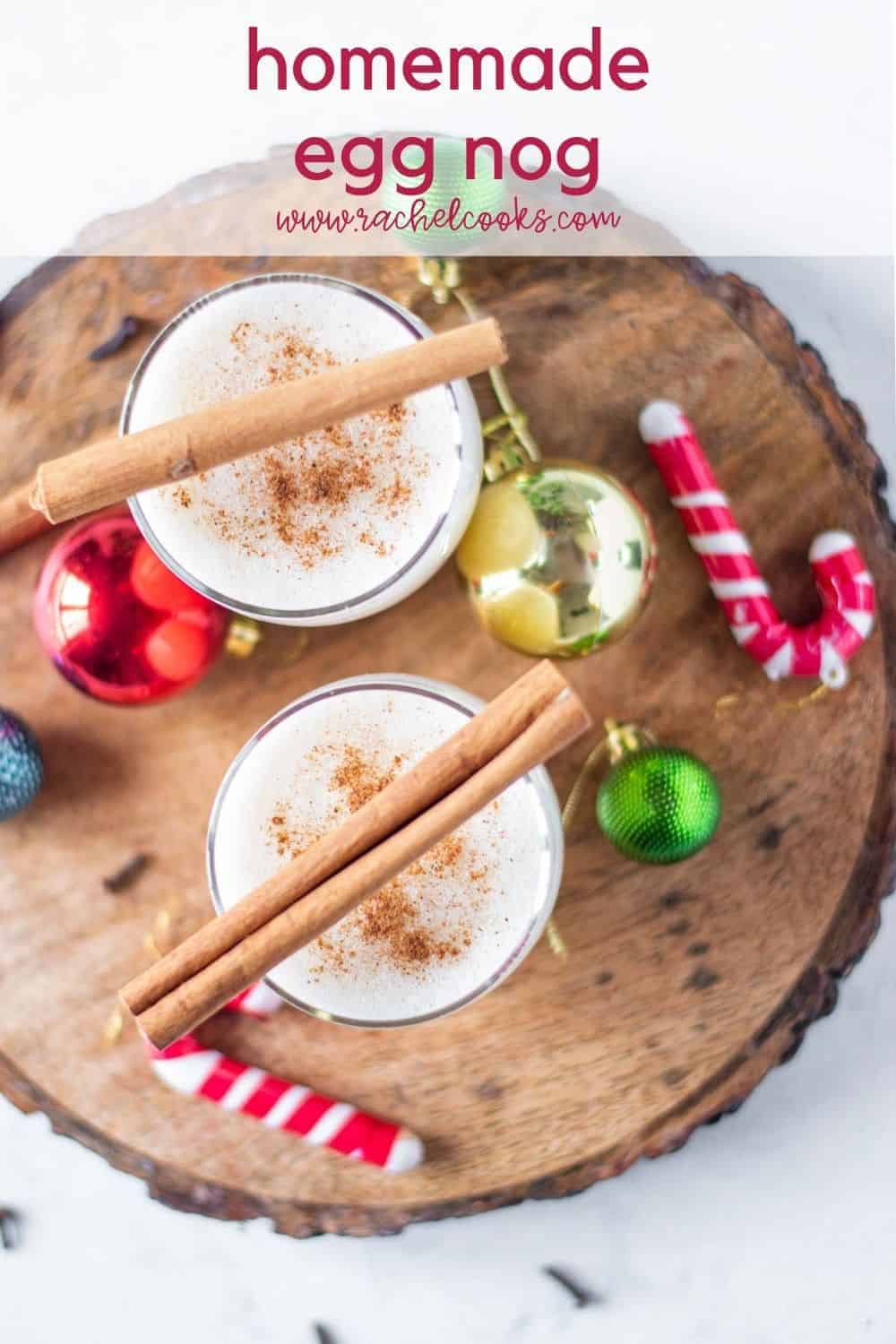 Overhead view of two glasses of egg nog, topped with cinnamon sticks.