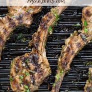 Overhead view of lamb on a grill pan. Text overlay reads "garlic herb grilled lamb chops, rachelcooks.com"