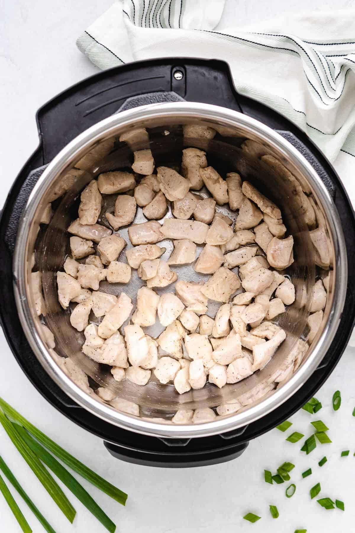 Cubes of cooked chicken in an instant pot.