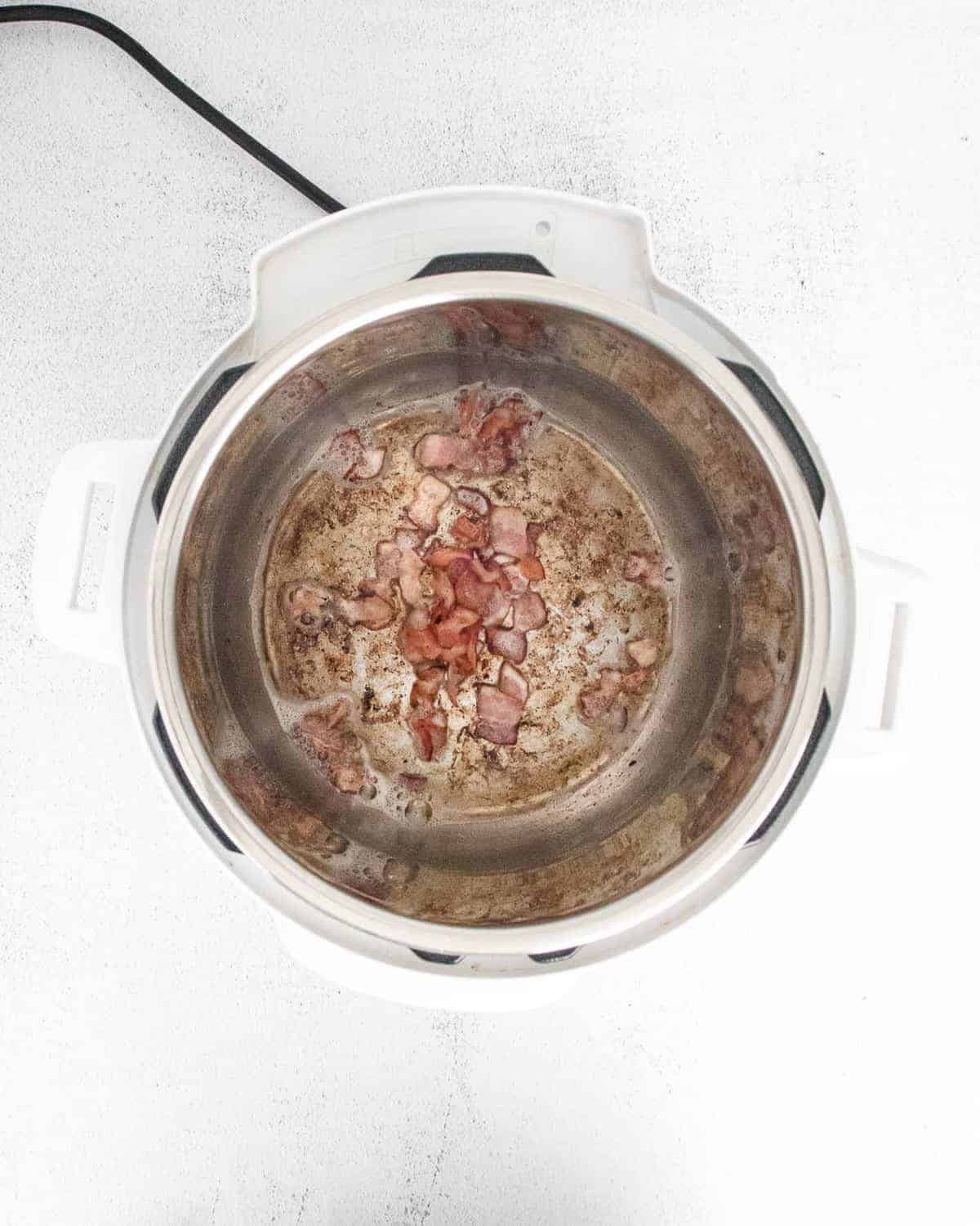 Bacon being sautéed in an instant pot.