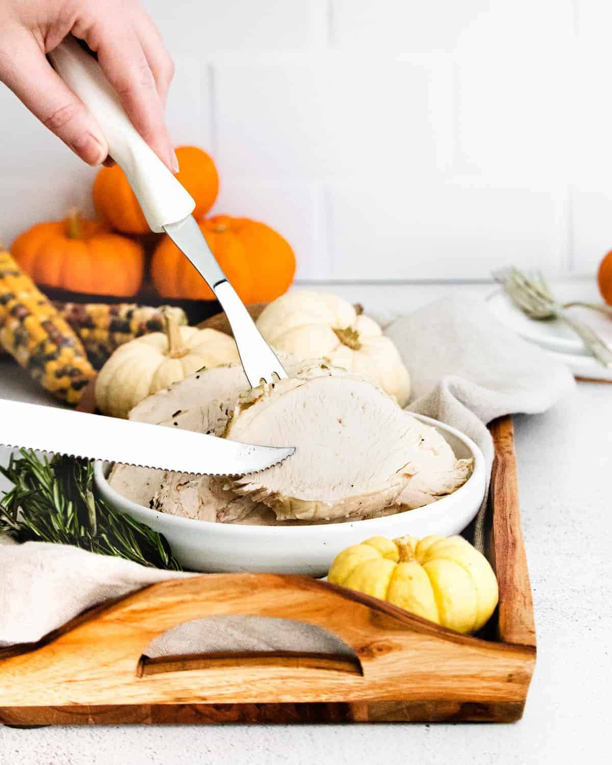 Turkey breast being sliced and served with silver knife and fork.