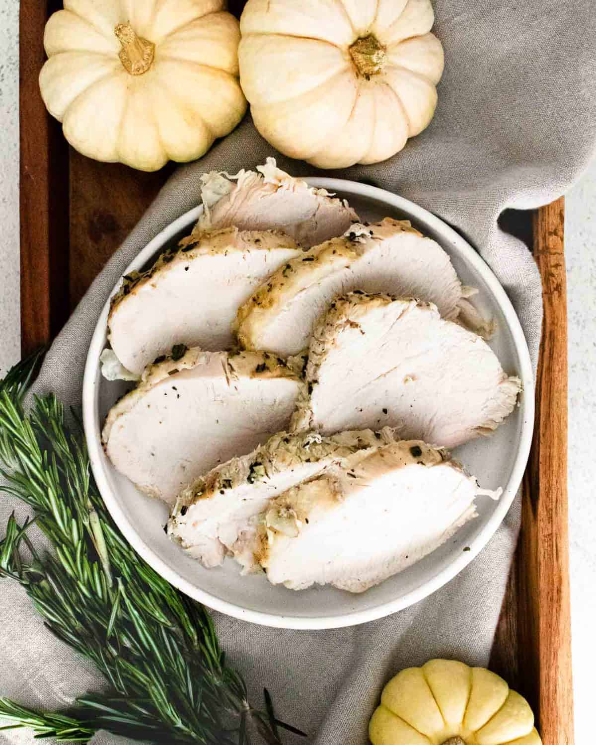 Overhead view of white meat turkey sliced on a white platter.