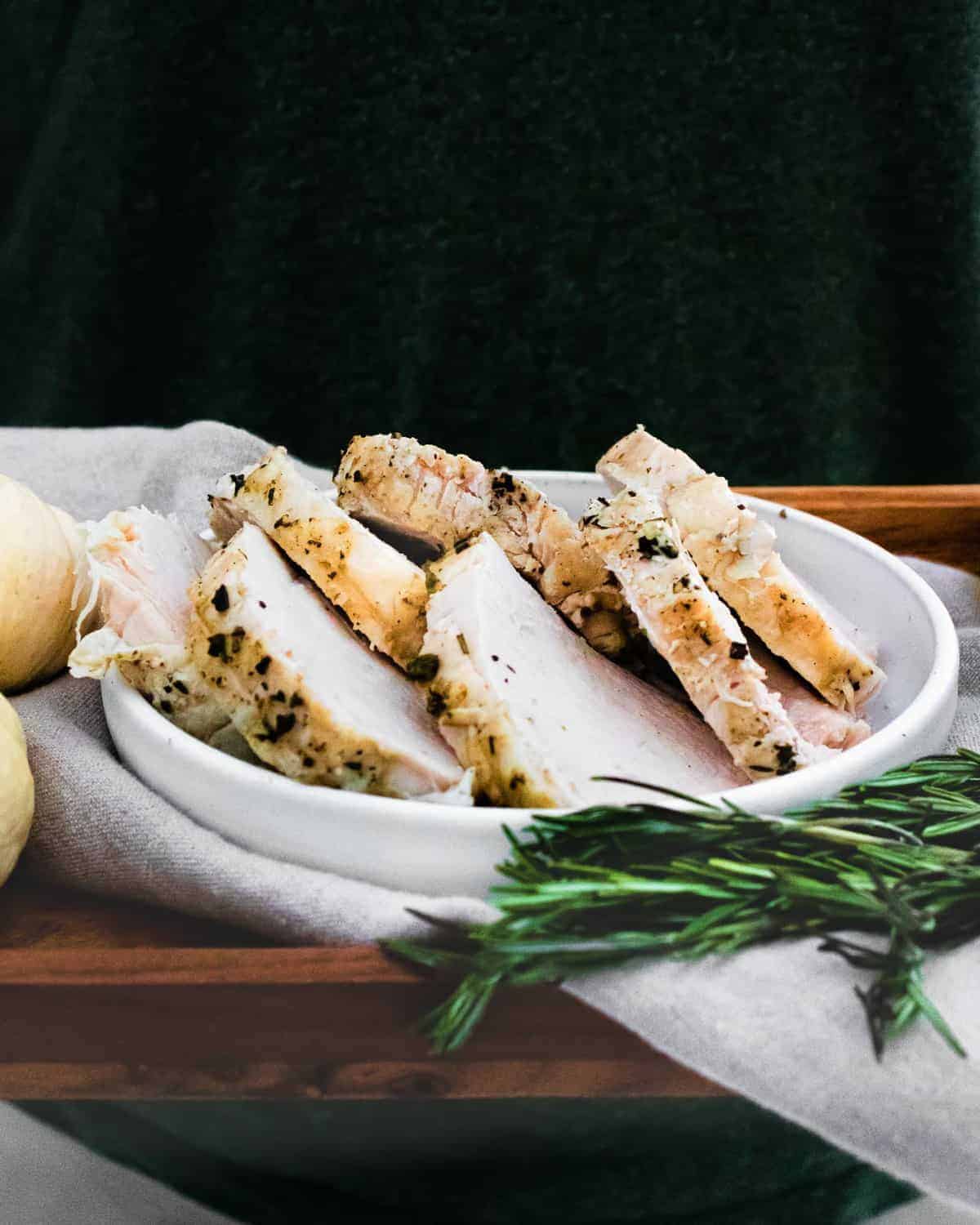 Slices of turkey on a platter, black background.