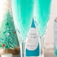 Two bright blue drinks with coconut rims, text overlay reads "jack frost mimosas, rachelcooks.com"