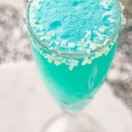 Two bright blue drinks with coconut rims, text overlay reads "jack frost mimosas, rachelcooks.com"