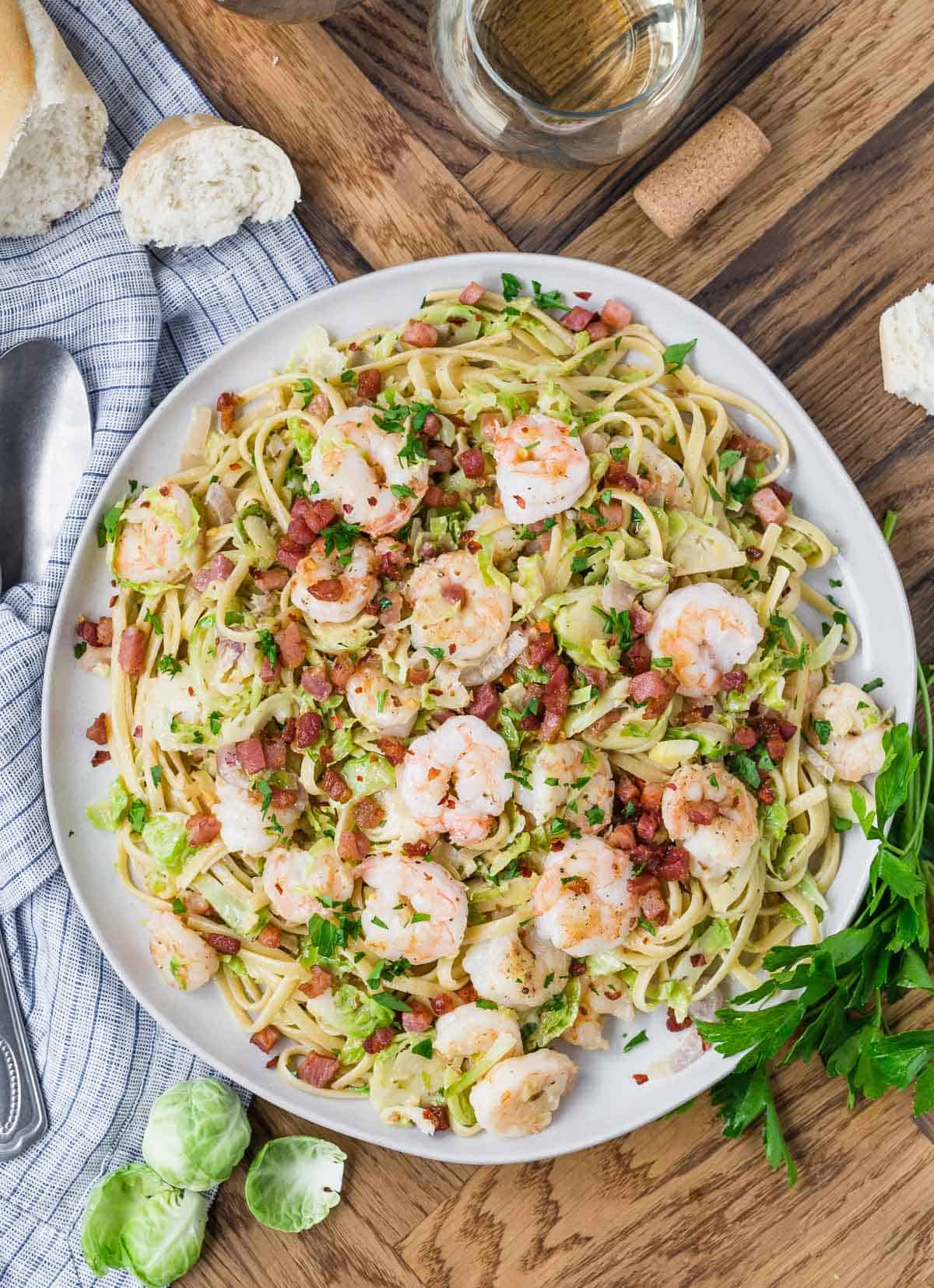 Overhead view of a large platter of shrimp pasta.