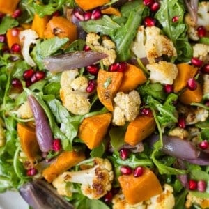 Close up of arugula salad with roasted cauliflower and sweet potatoes.