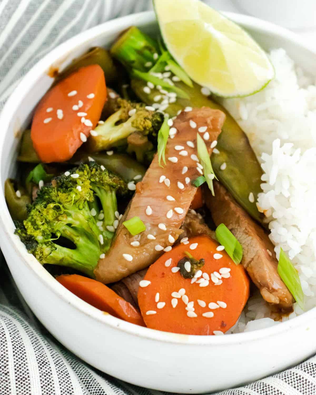 Close up image of sesame topped beef, vegetables, and rice.