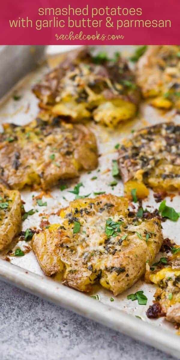 Potatoes on a sheet pan, text overlay reads "garlic parmesan smashed potatoes"
