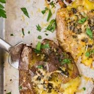 Potatoes on a sheet pan, text overlay reads "smashed potatoes with garlic butter"