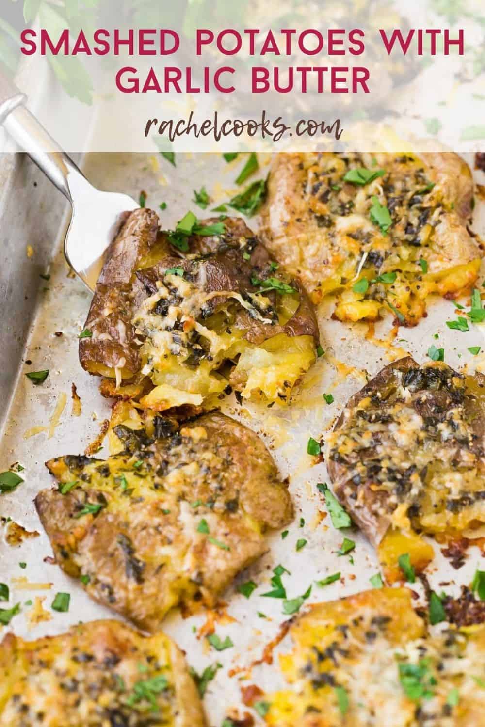 Potatoes on a sheet pan, text overlay reads "smashed potatoes with garlic butter"