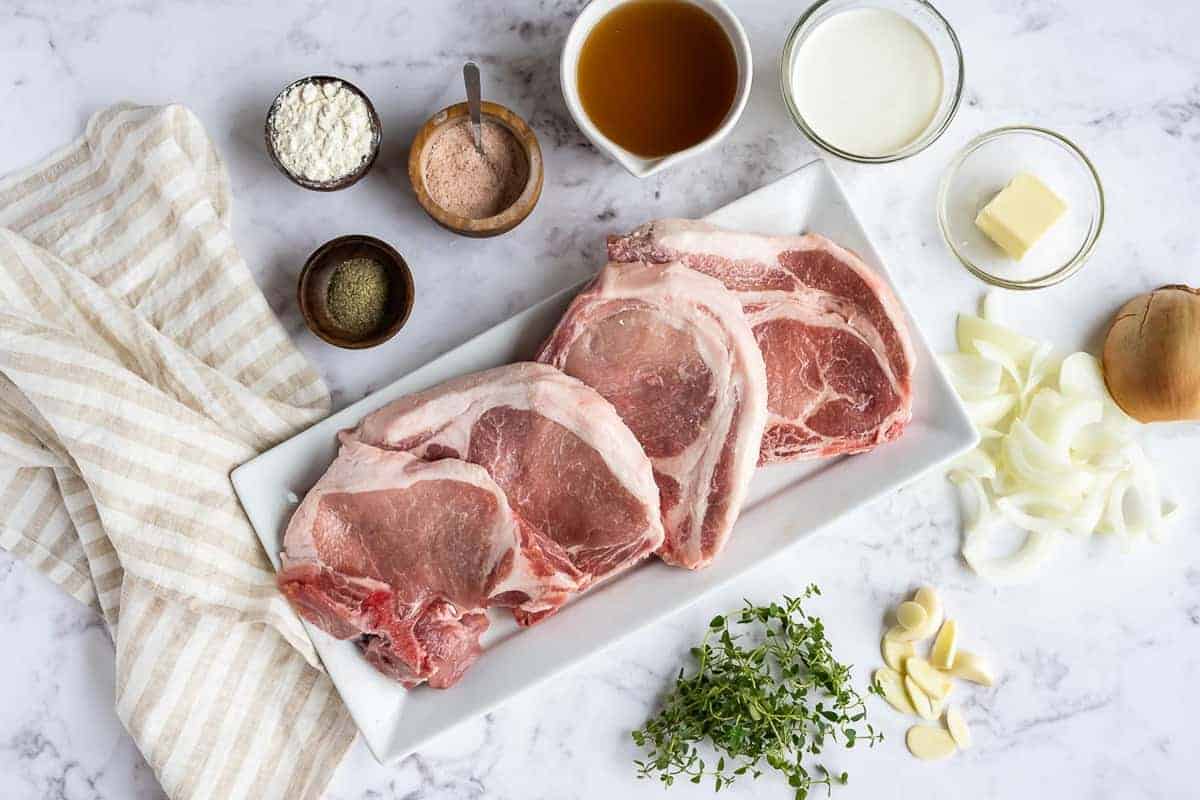 Overhead view of ingredients: Pork, spices, onions, thyme, cream, and more.