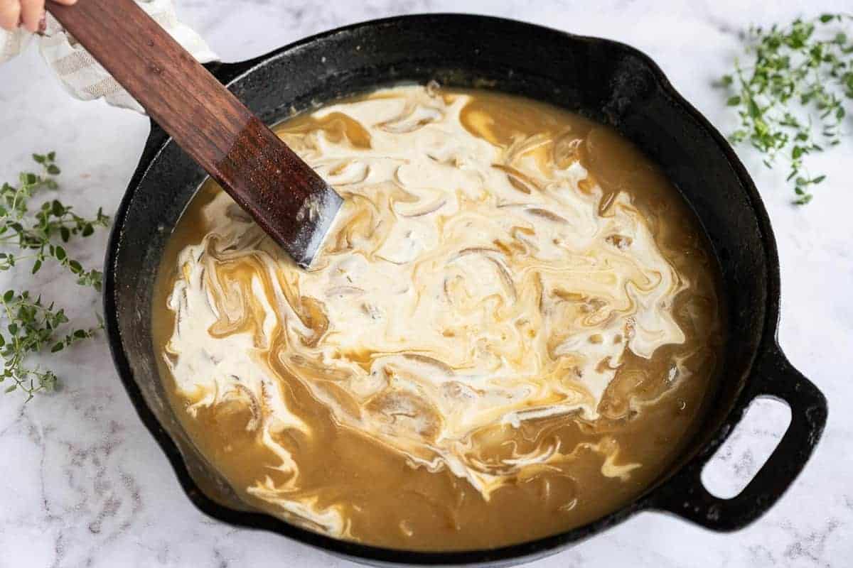 Cream being stirred into sauce.