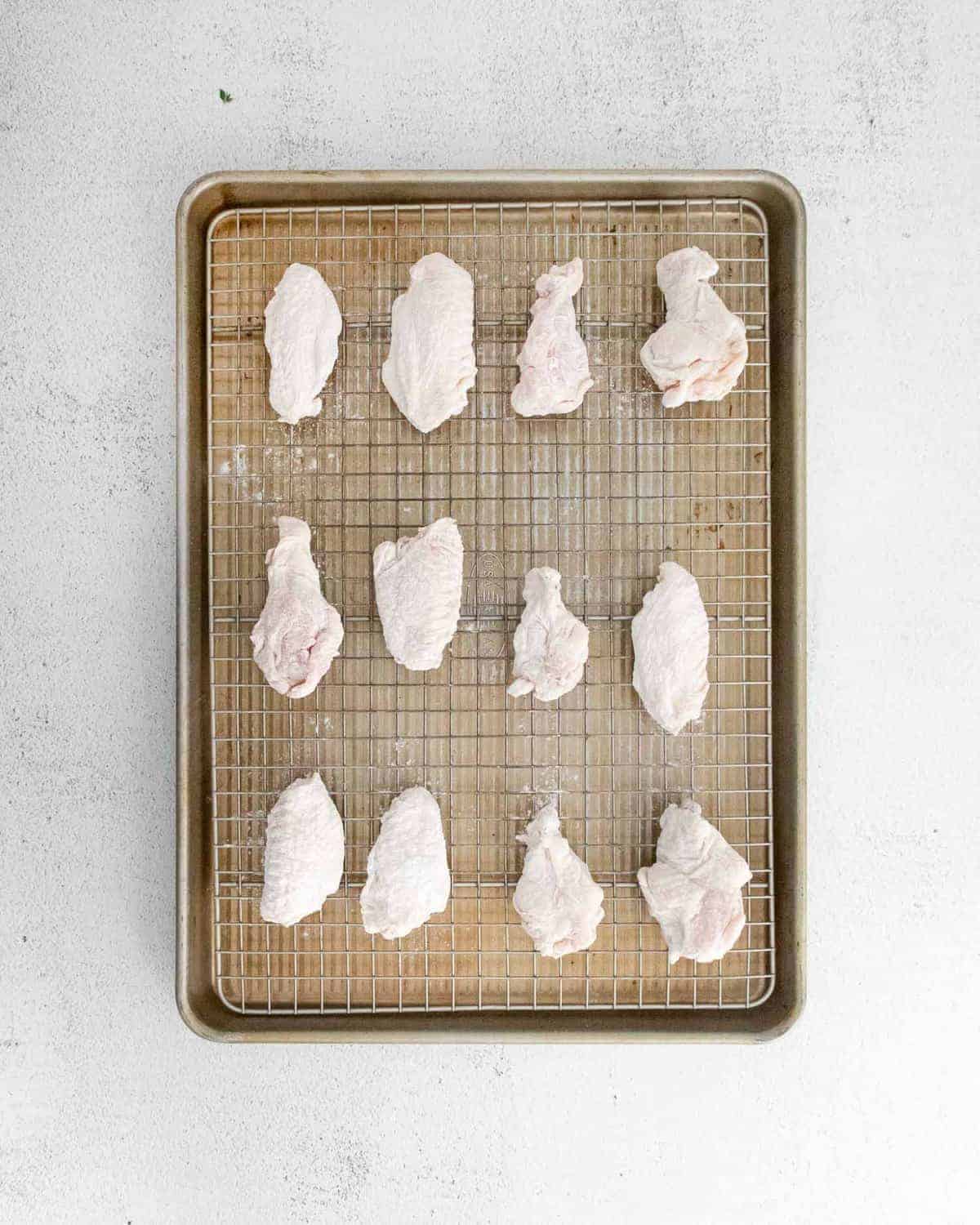 Unbaked wings on a baking sheet.