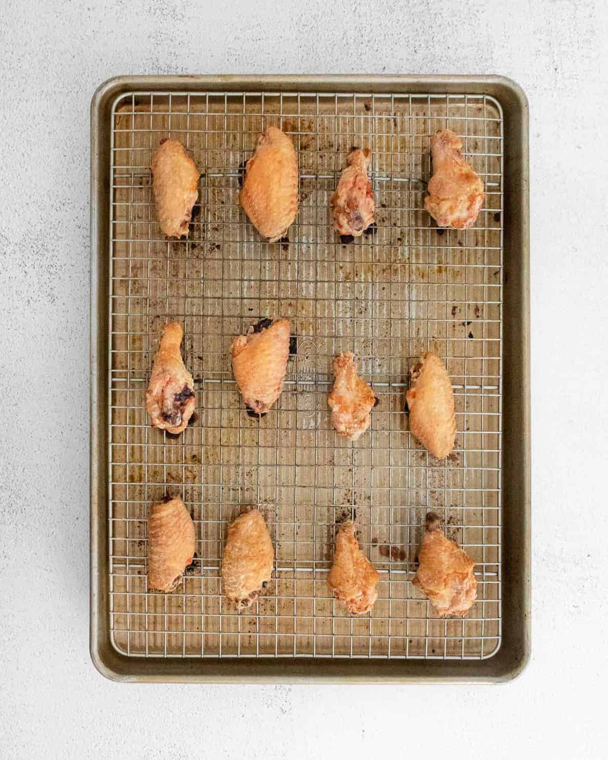 Baked chicken wings on a baking sheet.