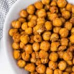 Overhead view of crispy seasoned chickpeas in a white bowl.