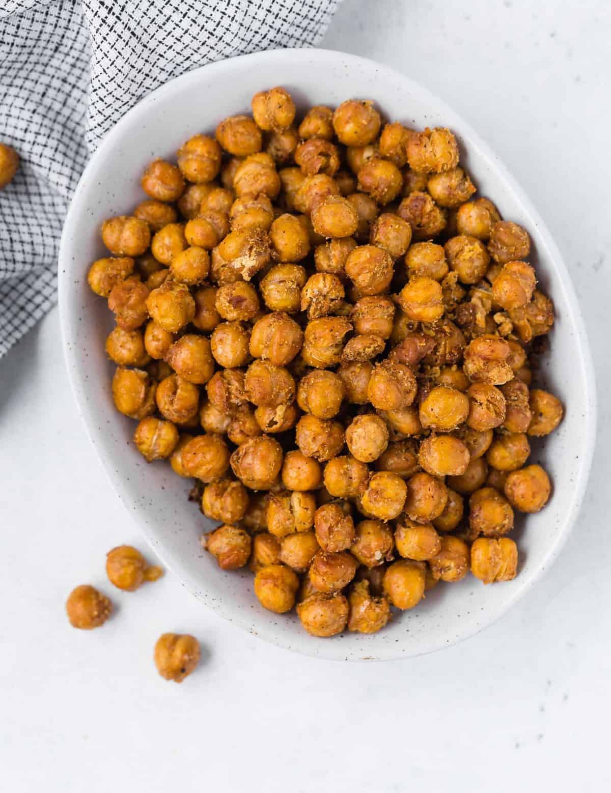Overhead view of a white bowl filled to the brim with golden-brown fried chickpeas.