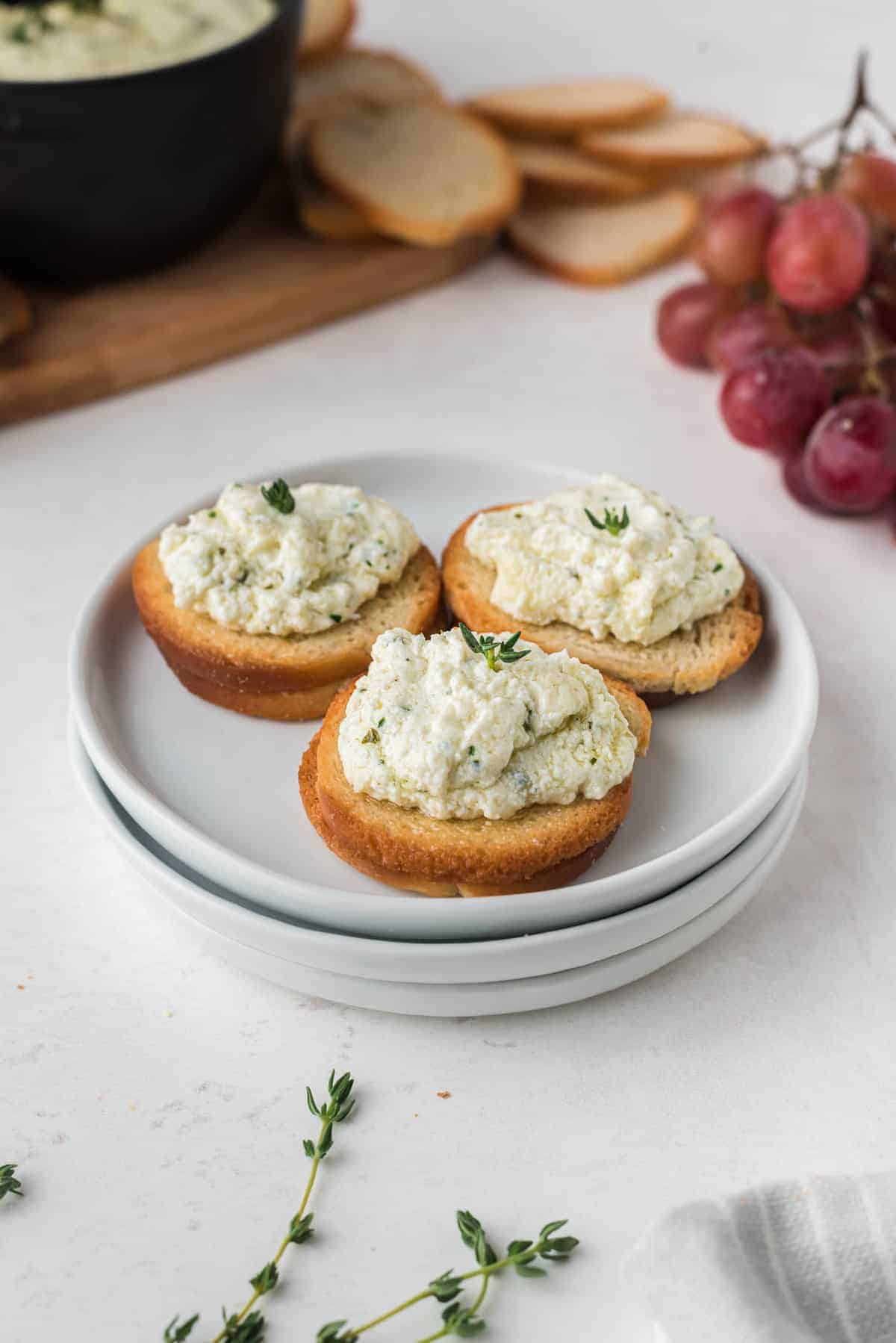 Goat cheese spread onto round toasts.