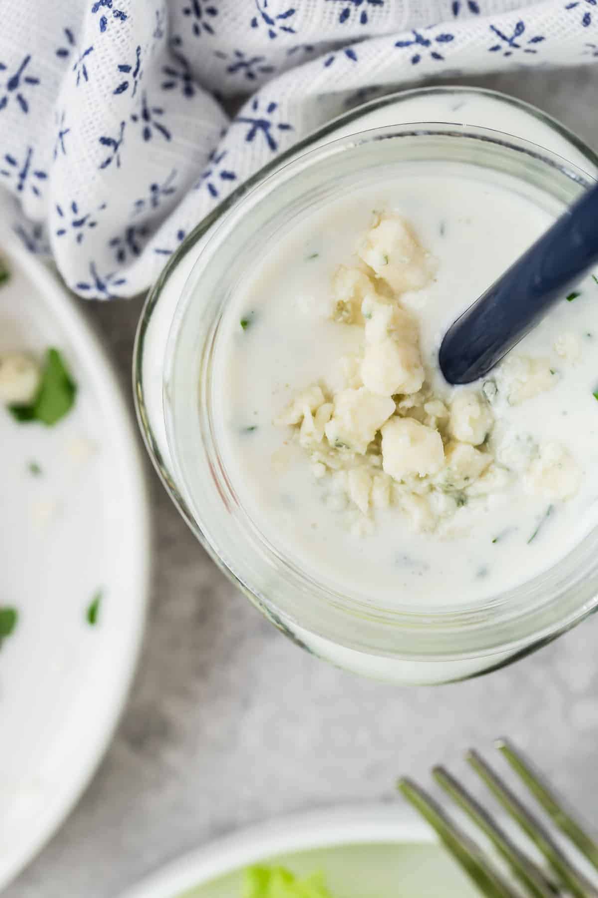 Overhead view of a jar of creamy dressing topped with blue cheese crumbles.