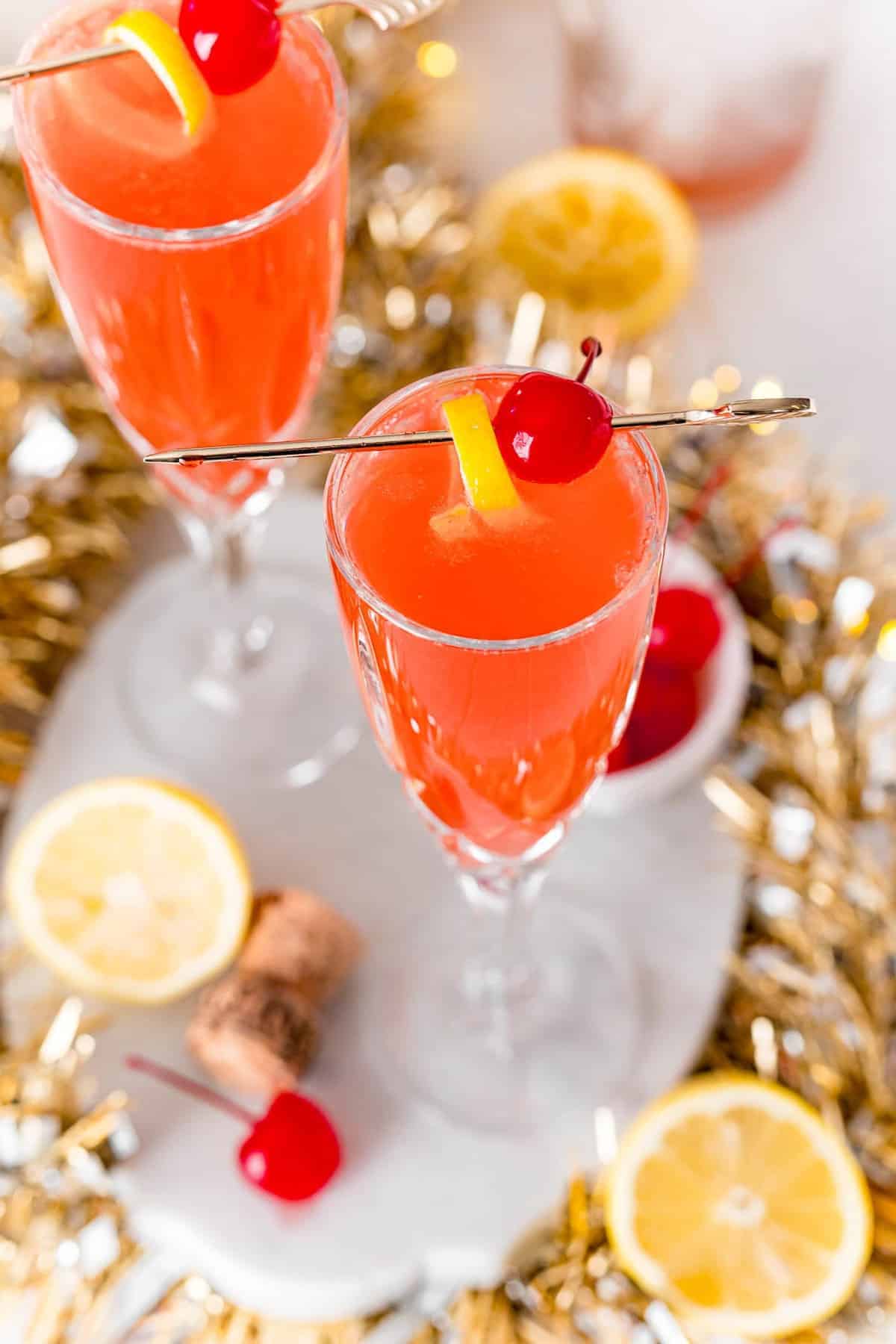 Overhead view of a champagne glass full of a cherry flavored french 75.