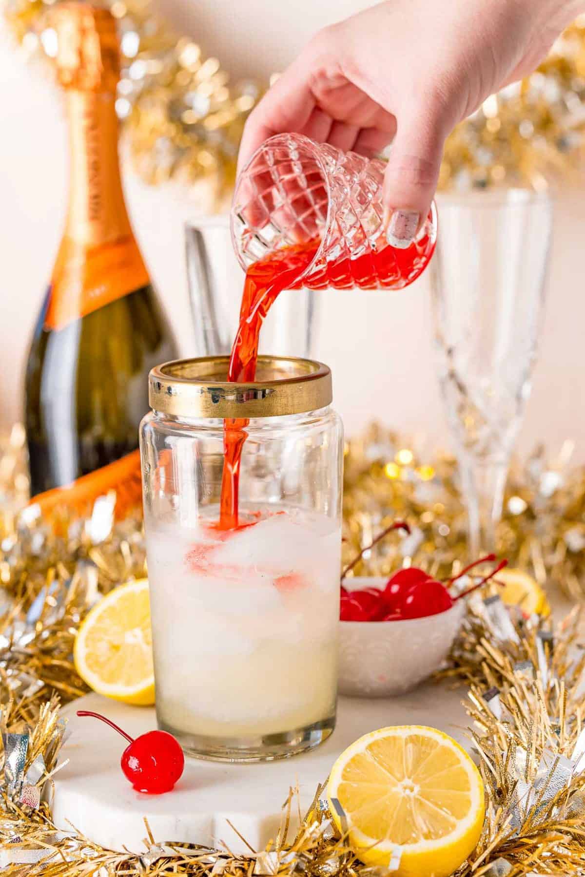 Cherry juice being poured into a cocktail shaker.