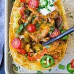 Spaghetti squash full of bell peppers, onions, chicken and cheese. It is topped with sour cream, jalapeno, tomato, and sour cream.