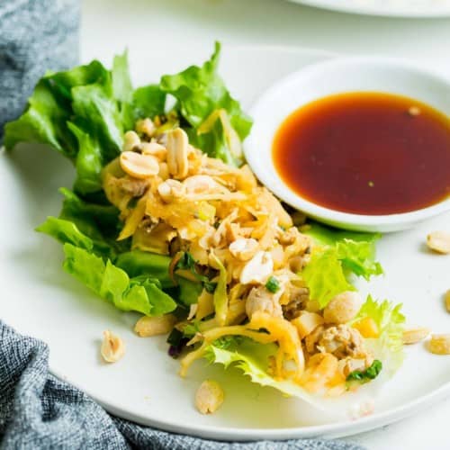 Lettuce wrap on a plate with dipping sauce.