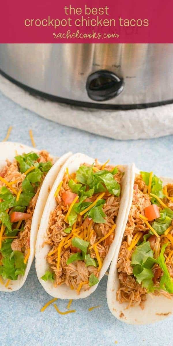 Shredded chicken on a tortilla with cheese, lettuce, and tomatoes. Text overlay reads "the best crockpot chicken tacos"