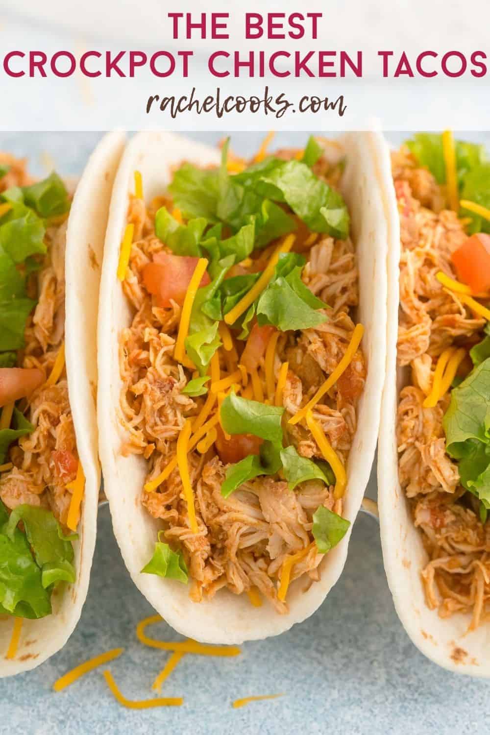 Shredded chicken on a tortilla with cheese, lettuce, and tomatoes. Text overlay reads "the best crockpot chicken tacos"