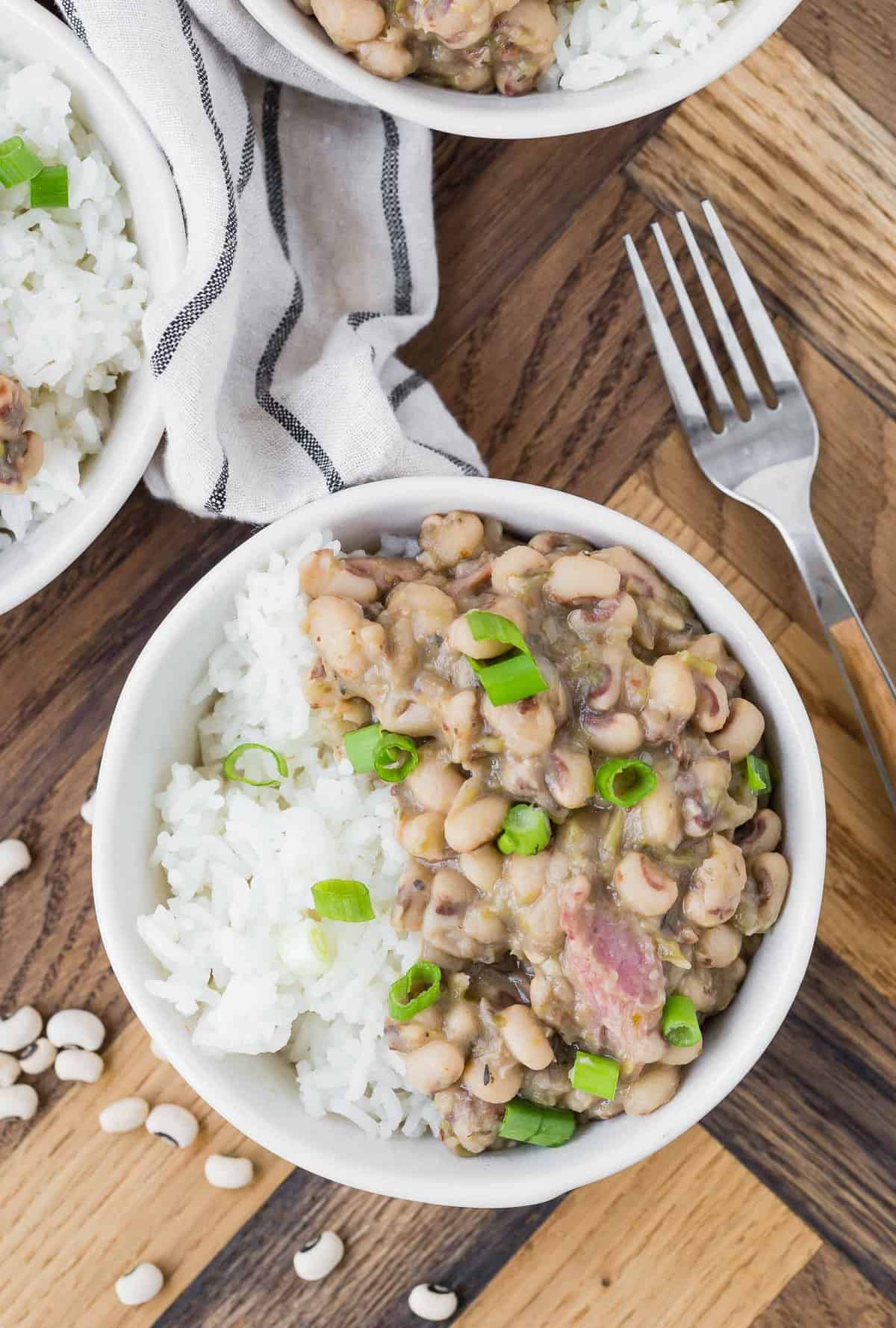 Overhead view of cooked black eyed peas served over white rice.