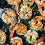 Lemon pepper shrimp in a black pan.