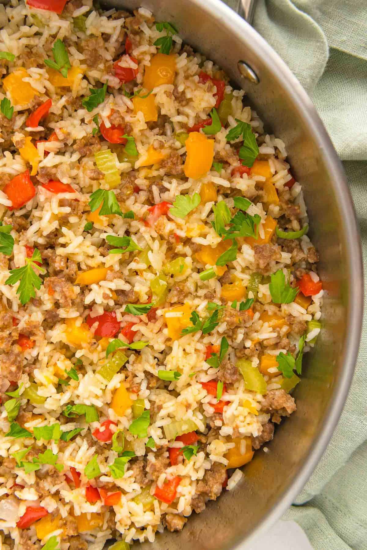 Cooked sausage, rice, and vegetables in a pan.