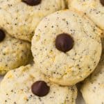 Close up of an orange and poppyseed cookie, with a chocolate chip in the center.