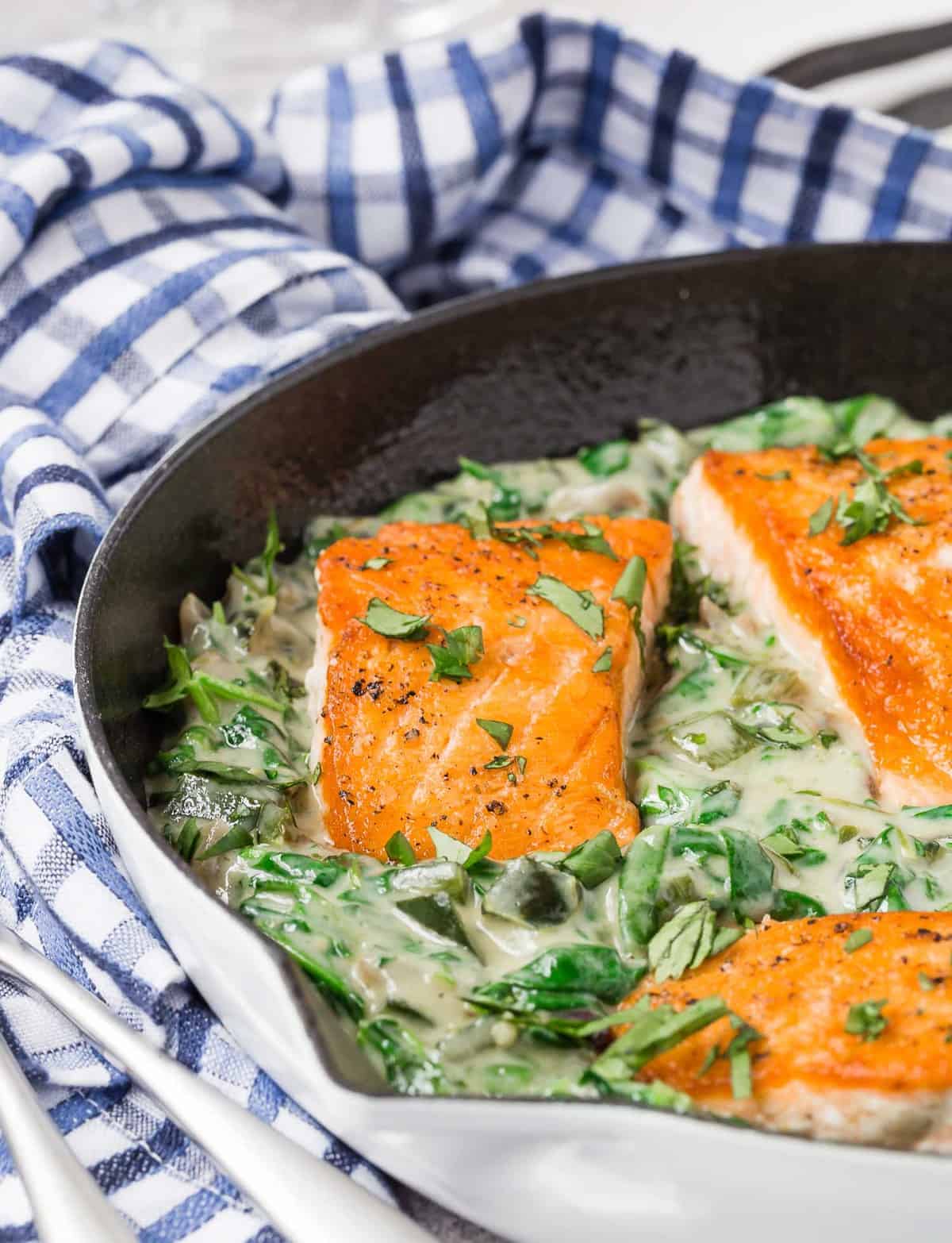 Salmon fillets nestled in skillet with poblano sauce.