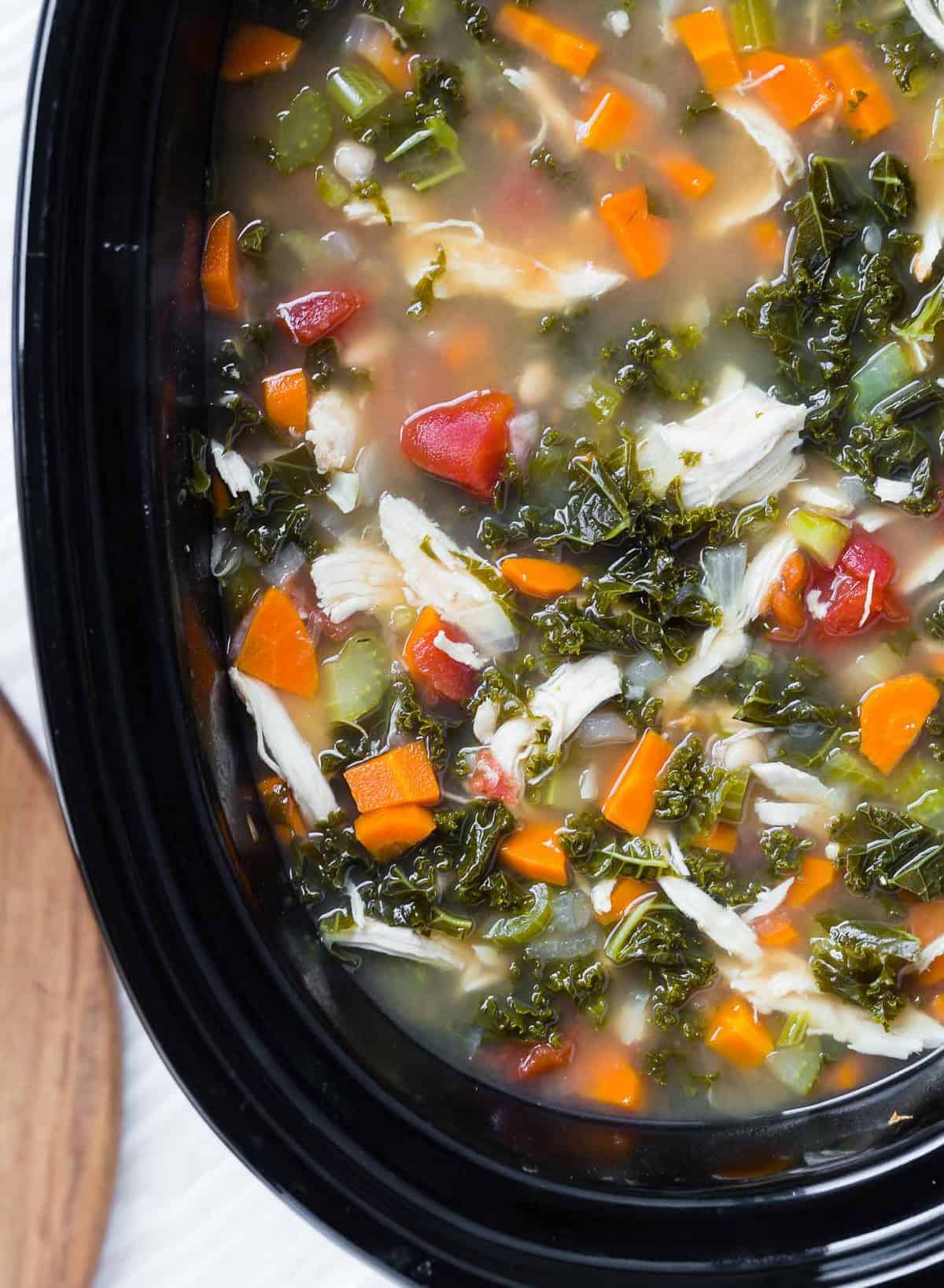 Close up of soup in a black slow cooker.