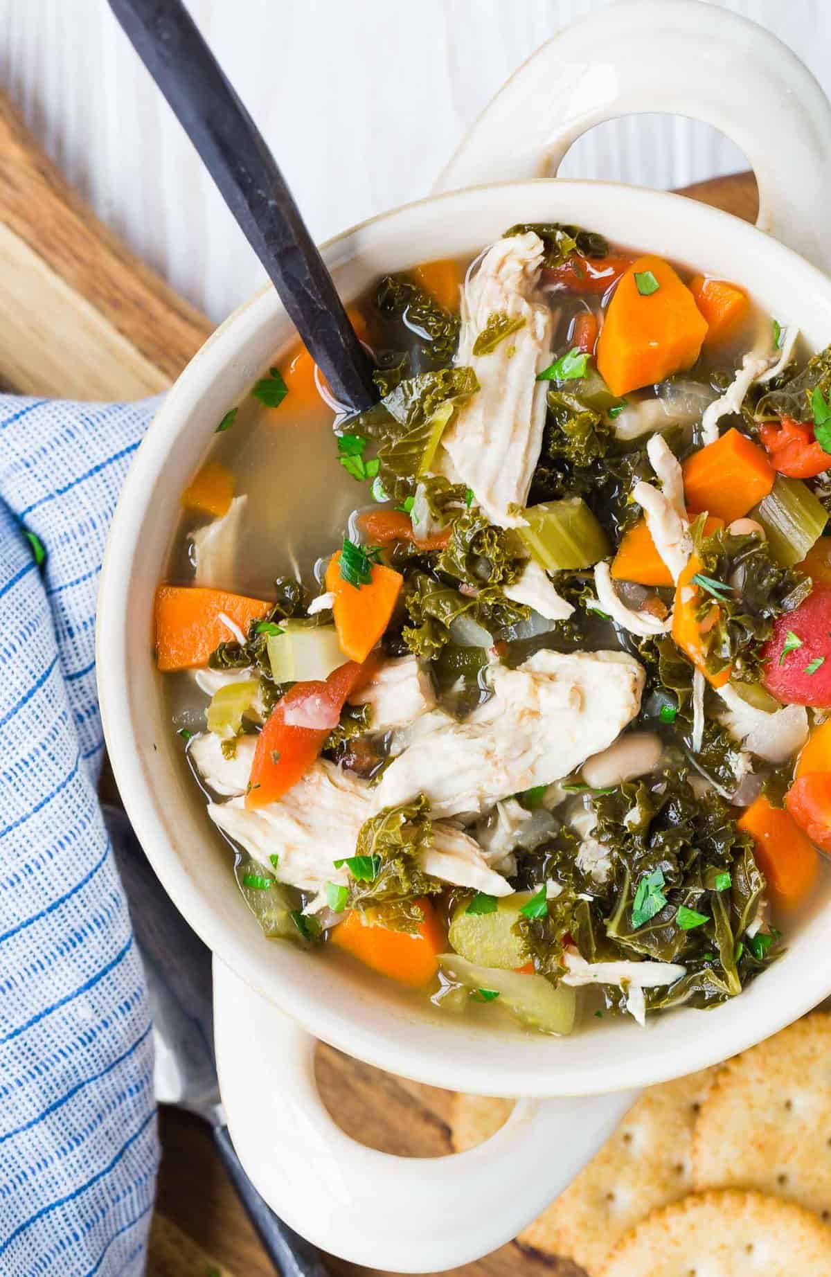 A bowl of soup with a black-handled spoon in it.