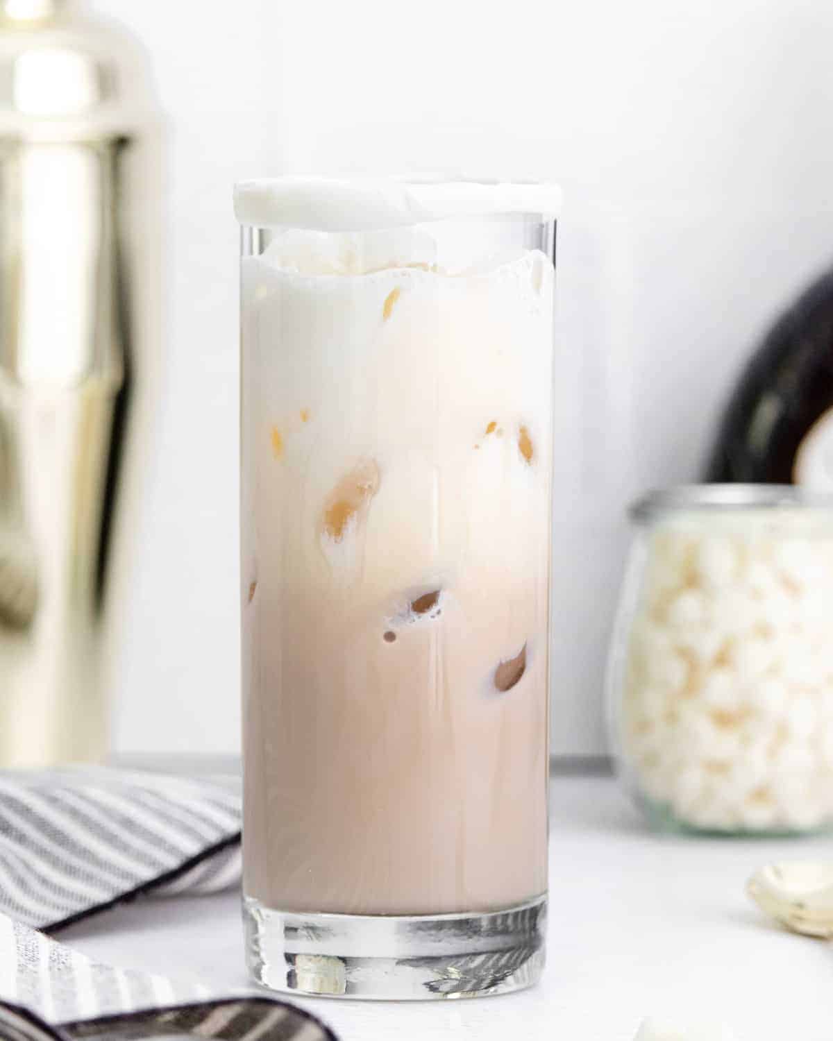 Drink with a light brown layer, a light white layer, and ice.
