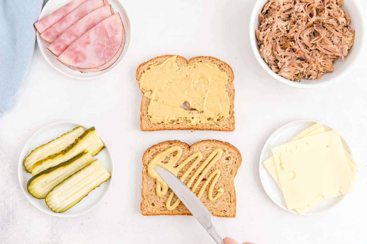 Mustard being spread on bread.