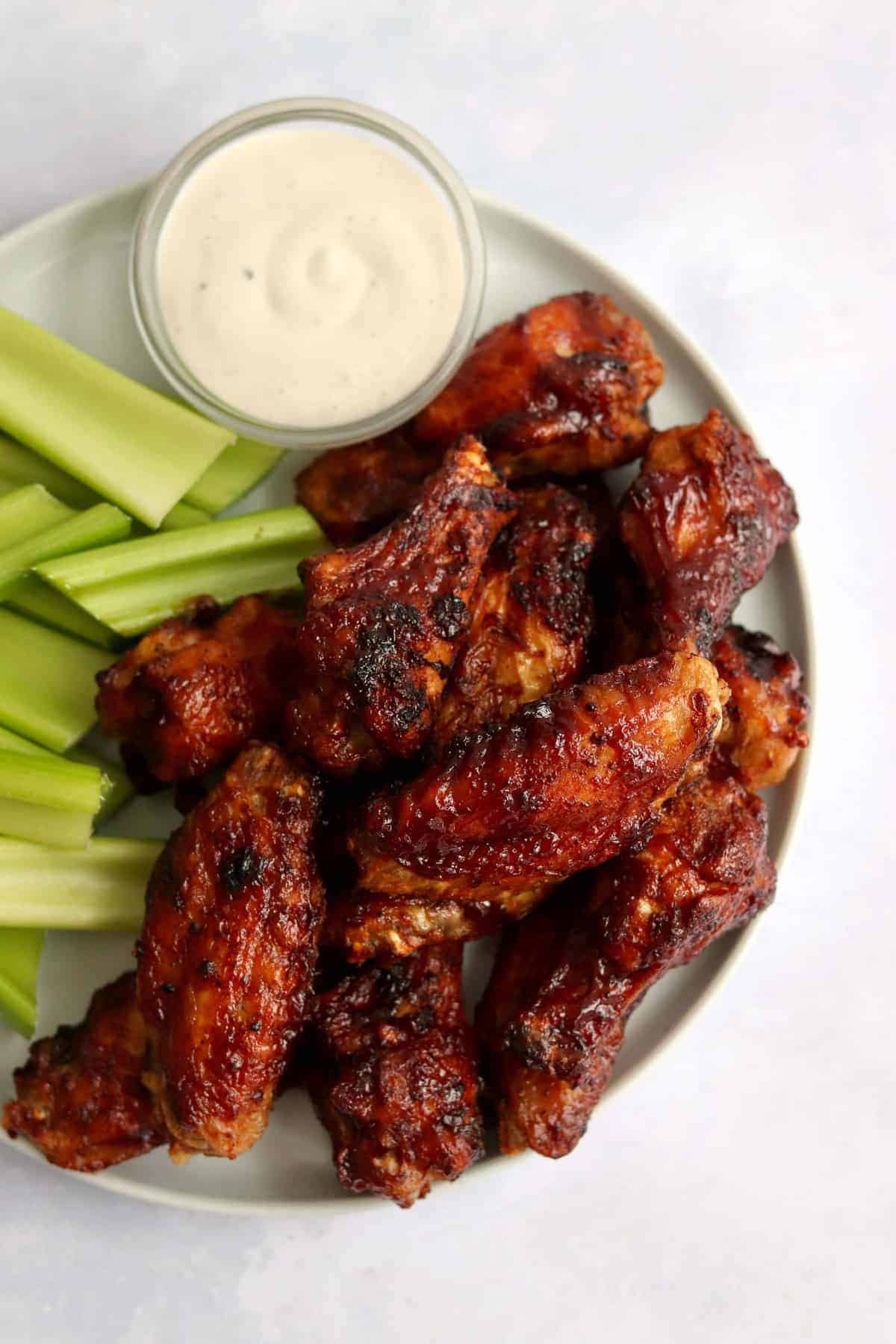 Chicken wings on a plate with celery and ranch.