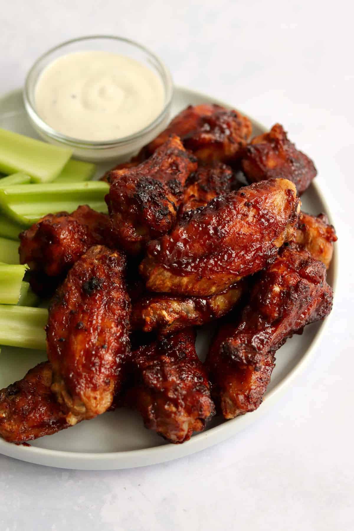 Wings piled up on a plate.