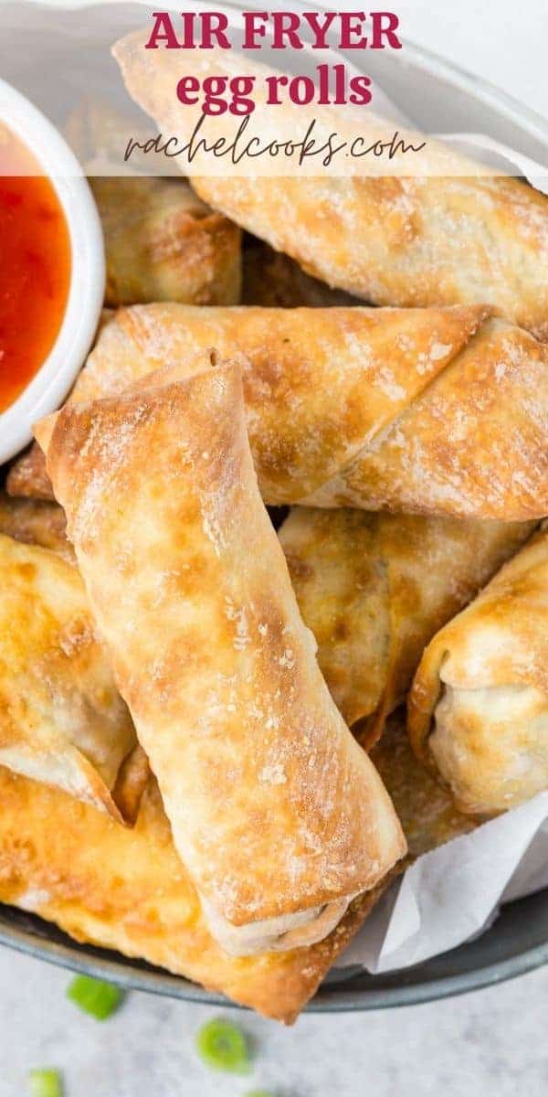 Metal basket of egg rolls, text overlay reads "air fryer egg rolls, rachelcooks.com"