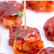 Close up of an appetizer on a toothpick, text overlay reads "easy bacon wrapped water chestnuts"