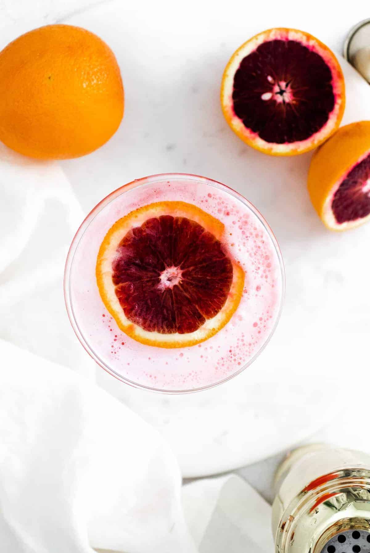 Overhead view of a drink with a slice of blood orange floating in it.
