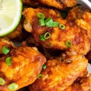 Wings in a white dish, text overlay reads "chili lime chicken wings"
